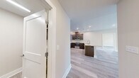 This thoughtfully designed 2-bedroom, 2-bathroom residence at 4805 W Genesee St in Syracuse, New York offers a comfortable and modern living experience across a single floor. Light gray wood-look flooring flows throughout, complementing the neutral warm-toned walls and crisp white trim that give the space a clean, contemporary feel.

The open-concept kitchen is a standout feature, showcasing rich dark-stained shaker cabinetry, granite countertops, a herringbone tile backsplash, and stainless steel appliances including a French door refrigerator and built-in microwave. A peninsula with a granite countertop and undermount sink connects the kitchen seamlessly to the living area, ideal for both everyday use and entertaining.

The spacious living room receives generous natural light through large windows and features a statement multi-blade ceiling fan. The generously sized primary bedroom offers ample room for a full furniture arrangement, while the second bedroom provides flexible use as a guest room or home office.

Both bathrooms are finished with marble-look tile flooring, dark wood vanities, and granite countertops. The primary bathroom features a double vanity and a glass-enclosed shower, while the second bathroom includes a tiled tub-shower combination. A dedicated laundry room houses a full-size GE washer and dryer, adding everyday convenience to this well-rounded residence.