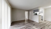 This single-story, 2-bedroom, 2-bathroom home on Seton Lake Drive in Houston, TX offers a functional and well-appointed layout throughout. The open living area is highlighted by durable wood-look flooring in a warm gray tone, a tiled fireplace as a focal point, and sliding glass doors dressed with vertical blinds that invite natural light. The living space flows seamlessly into a galley-style kitchen featuring gray cabinetry, granite-look countertops with a breakfast bar, a gas range, and black appliances including a refrigerator and dishwasher, all beneath recessed overhead lighting.

Both bedrooms are comfortably sized, each equipped with ceiling fans, natural light from window blinds, and wood-look flooring that carries throughout the home. Each bedroom is paired with its own dedicated walk-in closet outfitted with wire shelving for ample storage. The two bathrooms are finished in a clean, bright white palette, with one featuring a full tub-shower combination with tiled surround. Neutral gray walls tie the entire home together, creating a cohesive, modern aesthetic that is both practical and inviting.
