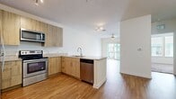 This 670 square foot apartment in Orlando, FL offers a thoughtful blend of comfort and functionality. The single-floor layout comprises one bedroom, one bathroom, and an open-concept living area. The kitchen is a standout feature, boasting modern wood-grain cabinetry, stainless steel appliances, and elegant granite countertops. A kitchen island doubles as a breakfast bar, enhancing the space's versatility.

The living room flows seamlessly from the kitchen, featuring wood-look flooring that extends throughout the main living areas. Large windows in the living room and bedroom allow ample natural light, creating a bright and airy atmosphere. The bedroom, measuring 120 square feet, offers plush carpeting for added comfort.

The bathroom is designed with clean lines, featuring a white tile surround for the bathtub/shower combination and modern fixtures. A hallway provides access to all rooms and includes a closet for additional storage. The apartment's neutral color palette and contemporary finishes create a cohesive, modern aesthetic throughout the space.

A sliding glass door in the living area leads to a private balcony, offering an outdoor extension of the living space. This efficient floor plan maximizes every square foot, making it an ideal choice for those seeking a compact yet stylish urban dwelling in Orlando.