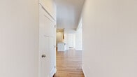 Located at 11684 N Standard Dr in Spokane, WA, this well-designed one-bedroom, one-bathroom unit offers a thoughtfully laid-out single-floor plan. The open-concept living area is bathed in natural light from large windows and a glass door that leads to a private balcony, offering views of the surrounding tree line. Light-toned hardwood flooring runs throughout the main living spaces, lending a clean, modern aesthetic to the interior.

The kitchen is a functional centerpiece of the unit, featuring a peninsula with a white countertop that doubles as a breakfast bar with bar seating. Warm wood cabinetry, stainless steel appliances — including a refrigerator, range, and microwave — and a built-in sink with pendant lighting above complete the space with both style and practicality.

The spacious bedroom is carpeted for comfort and includes a large sliding double-door closet, a dedicated window with natural light, and a baseboard heating system. The full bathroom is finished with warm wood vanity cabinetry, a white countertop, a large mirror, and a full tub/shower combo with hardwood-style flooring.

Throughout the unit, clean white walls, exposed ceiling beams in the living area, and consistent warm-toned finishes create a bright, cohesive, and inviting atmosphere.