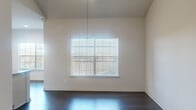 Located at 14811 West Rd in Houston, TX, this well-appointed one-bedroom, one-bathroom residence offers a thoughtfully designed single-floor layout. The living and dining areas feature dark hardwood-style flooring and large windows fitted with white blinds that invite an abundance of natural light, creating a bright and airy atmosphere throughout.

The kitchen is a standout feature, showcasing white shaker-style cabinetry, granite countertops, a grey subway tile backsplash, and a full suite of stainless steel appliances including a refrigerator, range, and over-the-range microwave. Light wood flooring adds warmth to this functional and stylish cooking space.

The bedroom is generously proportioned, finished with plush carpet flooring, a ceiling fan with light fixture, and a window with an outdoor view. It connects directly to a dedicated walk-in closet, providing ample storage. Elegant arched hallways with dark hardwood-style flooring lead to the bathroom, which features a white vanity with granite countertops.

A dedicated laundry area houses a full-size side-by-side washer and dryer, adding everyday convenience. The unit also includes a private entrance door with window and blinds. Clean neutral tones, modern finishes, and a cohesive design make this a comfortable and move-in ready space.