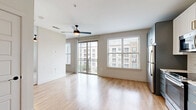 Located at 626 N Zang Blvd in Dallas, TX, this thoughtfully designed single-floor residence offers an efficient and modern living experience. The open-concept layout seamlessly connects the living area to the kitchen, creating a bright and cohesive space enhanced by light hardwood-style flooring throughout.

The kitchen is a standout feature, showcasing a two-tone design with upper white shaker cabinets and lower slate-blue cabinetry, all accented with gold hardware. A classic white subway tile backsplash complements the light countertops, while stainless steel appliances — including a refrigerator, electric range, microwave, and dishwasher — complete the functional setup. A built-in mudroom nook with a bench and hooks is conveniently positioned near the front entry.

The living area is filled with natural light, courtesy of large sliding glass doors that open to a private balcony offering views of the surrounding neighborhood. A ceiling fan adds comfort to the space.

The bathroom is well-appointed with a grey vanity featuring brass fixtures, a white countertop, penny-tile flooring, and subway-tiled walls surrounding the tub and shower. A dedicated closet provides essential storage. The unit's clean, neutral palette and modern finishes create a cohesive and inviting atmosphere throughout.
