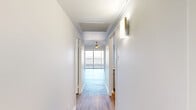 Located at 99 N Main St in the heart of downtown Memphis, Tennessee, this efficiently designed unit offers a thoughtful layout across a single floor. Wood-style plank flooring runs throughout, lending a clean, modern aesthetic to every room.

The bright, open living room is anchored by a ceiling fan and flooded with natural light from a large sliding glass door that leads directly to the private balcony. From this outdoor space, expansive panoramic views of the surrounding Memphis skyline and landscape provide a striking backdrop. The kitchen is positioned as an open pass-through with white cabinetry, stainless steel appliances, and a breakfast bar that connects seamlessly to the living area.

A clean, well-lit hallway connects the primary spaces to two closets and two bathrooms. The bathrooms feature white subway tile in the tub/shower surround, a wide vanity with a solid white countertop, gray shaker-style cabinetry, brushed nickel fixtures, and a large mirror that amplifies the sense of light. The neutral white walls throughout the unit maintain a bright and airy ambiance, making the space feel open and inviting. The efficient floor plan makes excellent use of every square foot, offering a functional and comfortable living environment in a prime downtown Memphis location.