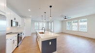 Located at 3200 Meadow Gate Ln in Davenport, FL, this well-appointed 2-bedroom, 2-bathroom single-story home offers a bright, modern living experience with a thoughtfully designed open-concept layout. The kitchen serves as the centerpiece of the main living area, featuring a large island with a sleek white quartz countertop, a matte black gooseneck faucet with an undermount sink, white shaker cabinetry with black hardware, stainless steel appliances, and stylish glass pendant lighting. The kitchen flows seamlessly into the living area, which is bathed in natural light from multiple windows and equipped with a ceiling fan. Light wood-tone flooring runs throughout the home, complementing the clean, white interior palette. A wide hallway connects the living spaces to the private bedrooms, each offering ceiling fans, natural light, and generous closet space, including a walk-in closet with wire shelving. The spacious primary bathroom features a dual-sink vanity with white cabinetry, black-framed mirrors, matte black fixtures, and a glass-enclosed walk-in shower with tile surround. A dedicated laundry room houses a full-size washer and dryer. The home's contemporary design, abundant natural light, and quality finishes make it a comfortable and functional residence.