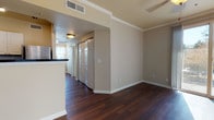 This single-floor residence at 1001 E 1st Ave in Broomfield, Colorado, offers a thoughtfully designed layout with a blend of modern finishes and comfortable living spaces. The entryway welcomes visitors with tile flooring that transitions into rich, dark hardwood extending throughout the main living and dining areas. Crown molding adds an elegant architectural detail throughout the common spaces, enhancing the overall polish of the interior.

The kitchen is well-appointed with white cabinetry, dark granite countertops, a subway tile backsplash, and a full suite of stainless steel appliances, including a range, microwave, dishwasher, and refrigerator. A breakfast bar peninsula provides additional counter space and casual dining options.

The living area is open and airy, bathed in natural light, and features a sliding glass door that opens to a private outdoor deck with exterior views — a notable feature for relaxing or entertaining. Crown molding continues here, complementing the ceiling fan overhead.

The bedrooms are carpeted for comfort, each equipped with ceiling fans, ample closet space, and large windows that allow generous natural light and outdoor views. One bedroom includes a spacious double-door closet configuration.

The bathroom is finished with dark granite countertops, white cabinetry, wood-look flooring, and a full shower-tub combination, maintaining a consistent and cohesive design aesthetic throughout the home.