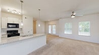 Located at 49 Sky Exchange Dr in Asheville, NC, this two-bedroom, one-bathroom single-floor home offers a bright, well-organized layout designed for comfortable living. The open-concept living and dining area is filled with natural light from large windows and French doors that lead to an outdoor space, complemented by plush carpeting and a ceiling fan overhead.

The kitchen is a standout feature, showcasing granite countertops, white cabinetry, a classic subway tile backsplash, and black appliances including a refrigerator, range, and microwave. Pendant lighting illuminates the peninsula with an undermount sink, which opens seamlessly to the living area. A dedicated pantry and wood-look flooring add practicality and style.

The generously sized primary bedroom benefits from dual windows with outdoor views and a ceiling fan, while the second bedroom also features natural light and soft carpeting. Both bedrooms are served by well-appointed closets. The full bathroom offers a granite-topped vanity, wood-look tile flooring, and a tub-shower combination.

Additional highlights include a dedicated laundry area with shelving, a hallway connecting all rooms efficiently, and five closets providing ample storage throughout the home.