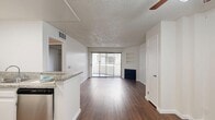 Located at 825 S Hobart Blvd in the heart of Los Angeles' Koreatown neighborhood, this one-bedroom, one-bathroom unit offers a well-planned, single-story layout with consistent hardwood-style flooring throughout. The open living area serves as the centerpiece of the unit, featuring a fireplace, built-in wall shelving, and a ceiling fan. A full-width sliding glass door floods the space with natural light and provides access to an outdoor area. The kitchen is efficiently designed with white shaker cabinetry, granite countertops, stainless steel appliances including a gas range and dishwasher, and a pass-through counter that connects to the living area. The bedroom offers a comfortable footprint with a sliding-door closet and neutral wall tones that complement the rich flooring. The bathroom is well-appointed with granite countertops, white cabinetry, and a shower/tub combination with sliding glass enclosure. Throughout the unit, a textured ceiling, clean white walls, and dark hardwood-style floors create a cohesive and functional aesthetic suited for everyday living in one of Los Angeles' most vibrant urban neighborhoods.