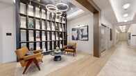 Located at 8000 Crescent Circle in Randolph, NJ, this generously sized single-floor amenity space is thoughtfully designed to deliver a premium community experience. The sweeping main corridor sets an immediate tone of sophistication, featuring light hardwood herringbone flooring, marble tile inlays, dark wood beam accents, and a curated series of pendant and recessed lighting that draws the eye through the length of the hallway.

The lounge and social areas are anchored by tray ceilings with warm cove lighting, a double-sided fireplace, and large windows that bring in natural light and outdoor views. A billiards table and ping pong table occupy a bold game room finished in deep teal cabinetry, built-in shelving, and statement artwork. A separate media room with a projector screen, turf flooring, and a sectional sofa provides a versatile entertainment venue.

A dedicated fitness center with professional-grade equipment occupies a substantial open area with polished concrete floors and glass-door access to adjoining rooms. Two private offices feature stylish wallcoverings, sit-stand desks, and wall-mounted monitors for focused work. The bathrooms offer wood-panel stall enclosures, stone-look tile floors, and refined pendant lighting. A balcony extends the space outdoors, completing this well-appointed amenity floor.