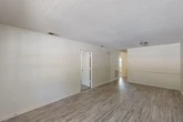 This single-story, two-bedroom, one-bathroom home on Lennox Drive in Albany, Georgia offers a practical and comfortable layout with a clean, neutral aesthetic throughout. The living room welcomes you with wood-look luxury vinyl flooring, a textured ceiling, and a front-facing window that allows natural light to fill the space — creating a bright and open atmosphere. A cheerful yellow front door adds a touch of character at the entryway. The kitchen is efficiently arranged in a U-shape and features gray cabinetry, light-toned countertops, and white appliances including a refrigerator, electric range, and dishwasher, with durable vinyl flooring underfoot. Both bedrooms are carpeted for comfort and each is fitted with a ceiling fan and window that brings in natural light. The primary bedroom is generously proportioned and connects conveniently to the bathroom, which includes a vanity with storage and a full soaking tub. Two closets provide ample storage throughout the home. The textured ceilings are consistent across all rooms, lending a cohesive look. A private outdoor area visible from the floorplan offers additional space for outdoor enjoyment. The home also benefits from two dedicated closets for storage convenience.