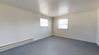 Located at 1127 Ward St in Chester, PA, this single-floor property offers a straightforward and functional layout. The interior is characterized by clean, neutral-toned walls and smooth ceilings that create a bright and open atmosphere throughout the space. The flooring is finished with wall-to-wall grey carpet, providing a comfortable and cohesive look underfoot. Natural light is a notable feature, with multiple windows fitted with white blinds allowing ample daylight to fill the rooms. The windows are positioned to offer good ventilation and visibility, enhancing the overall sense of openness. Baseboard heating units are present along the walls, ensuring efficient and consistent warmth throughout the colder months. The white baseboards and trim provide clean, crisp definition between the walls and floors, contributing to the tidy, well-maintained appearance of the interior. The overall ambiance of the space is clean, modest, and move-in ready, making it a practical option for those seeking a straightforward, low-maintenance property in the Chester, PA area.
