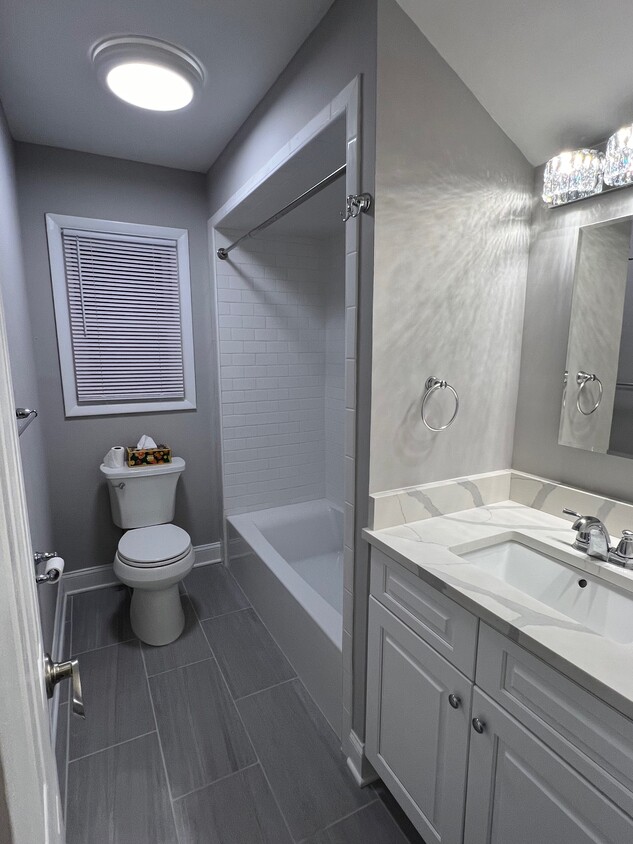 New bathroom, grey floor tile, chrome fixtures, two towel bars, robe hook and hand towel ring - 1445 Valley Rd