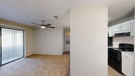 Located at 5800 Milgen Rd in Columbus, Georgia, this one-bedroom, two-bathroom residence offers a practical and well-appointed single-floor layout. The living room features plush carpeting, a ceiling fan with integrated lighting, and a large sliding glass door fitted with vertical blinds that opens to a private patio, allowing natural light to filter into the space.

The kitchen is designed with functionality in mind, featuring white shaker-style cabinetry, granite-look countertops, a peninsula breakfast bar, black appliances including a refrigerator and range, and pendant lighting overhead. Hardwood-style flooring in the kitchen and dining area provides a clean contrast to the carpeted living spaces.

The bedroom is a comfortable, well-sized room with soft carpeting, a ceiling fan, and a window for natural light. It provides direct access to one of the two full bathrooms, which is equipped with a granite-topped vanity, wood-style flooring, and a large mirror. The second bathroom features a full tub-shower combination with built-in shelving and chrome fixtures. A dedicated closet provides additional storage. The neutral color palette and consistent finishes throughout create a cohesive and move-in ready environment.