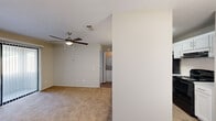Located at 5800 Milgen Rd in Columbus, Georgia, this one-bedroom, two-bathroom residence offers a practical and well-appointed single-floor layout. The living room features plush carpeting, a ceiling fan with integrated lighting, and a large sliding glass door fitted with vertical blinds that opens to a private patio, allowing natural light to filter into the space.

The kitchen is designed with functionality in mind, featuring white shaker-style cabinetry, granite-look countertops, a peninsula breakfast bar, black appliances including a refrigerator and range, and pendant lighting overhead. Hardwood-style flooring in the kitchen and dining area provides a clean contrast to the carpeted living spaces.

The bedroom is a comfortable, well-sized room with soft carpeting, a ceiling fan, and a window for natural light. It provides direct access to one of the two full bathrooms, which is equipped with a granite-topped vanity, wood-style flooring, and a large mirror. The second bathroom features a full tub-shower combination with built-in shelving and chrome fixtures. A dedicated closet provides additional storage. The neutral color palette and consistent finishes throughout create a cohesive and move-in ready environment.