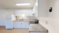 Located at 2500 Soquel Dr in Santa Cruz, California, this two-bedroom, one-bathroom residence offers a well-organized, single-level layout with a practical and clean aesthetic throughout. Light wood-style flooring runs consistently across the living areas and bedrooms, contributing to a bright and cohesive feel.

The kitchen is a standout feature, outfitted with crisp white shaker cabinetry, granite-style countertops, stainless steel appliances including an electric range, a full-size refrigerator, and a ceiling fan — all illuminated by a skylight-style flush ceiling fixture. The adjacent dining area provides a seamless transition for everyday living.

The living room is generously proportioned with neutral walls, a textured ceiling, a baseboard heating unit, and a sliding glass door that opens directly onto the balcony. From the balcony, residents enjoy open views of the surrounding landscaped community grounds and mature trees under the Santa Cruz sky.

Both bedrooms feature large sliding-door closets offering substantial storage capacity, with the primary bedroom providing a notably spacious footprint. The full bathroom includes a tiled shower-tub combination with brushed nickel fixtures and wood-style flooring.

A hallway connects the rooms efficiently, and three total closets throughout the unit further enhance storage options, rounding out this well-appointed Santa Cruz residence.