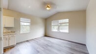 Located at 1325 W Tharpe St in Tallahassee, FL, this 2-bedroom, 2-bathroom unit offers a well-organized single-floor layout designed for comfortable everyday living. The open living and dining area is bright and welcoming, featuring light wood-look flooring and a vaulted ceiling with a ceiling fan. Multiple windows invite generous natural light and offer views of the surrounding greenery, enhancing the airy feel of the space. The kitchen is well-appointed with white shaker-style cabinetry, granite-look countertops, a deep undermount sink, and black stainless appliances, including a range, microwave, refrigerator, and dishwasher. Wood-look flooring continues throughout this area for a cohesive aesthetic. The primary bedroom features vaulted ceilings, multiple windows, and the same light flooring, creating a calm and spacious retreat. The second bedroom is finished with plush carpet, neutral walls, and a window with outdoor views. Both bathrooms are clean and functional, with one featuring a tub-shower combo, white tile surround, a white vanity with brushed nickel fixtures, and matching wood-look flooring. Additional highlights include four closets for ample storage, an in-unit laundry area, and a hallway connecting all rooms efficiently.