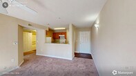 Located at 820 Martin Luther King Jr Pkwy in Durham, NC, this one-bedroom, one-bathroom residence offers a practical and well-organized single-floor layout. The combined kitchen and living area forms the heart of the home, where warm oak cabinetry, light countertops, and white appliances — including a refrigerator and electric range — define the kitchen space. A pass-through counter connects the kitchen to the living area, enhancing the open feel. The living room benefits from natural light streaming through a window and is equipped with a ceiling fan for year-round comfort. Soft wall-to-wall carpeting flows throughout the living and bedroom areas, while wood-style flooring anchors the kitchen and bathroom. The spacious bedroom features a ceiling fan with light fixture, a closet, and a window that fills the room with natural light. The bathroom is clean and functional, offering a wide vanity with an extended countertop, a large mirror with lighted fixtures, a tub-shower combo, and wood-style flooring. Additional storage is provided through multiple closets and a dedicated utility room. Textured ceilings and neutral warm-toned walls complete the cohesive, understated aesthetic throughout the home.