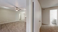 This single-story, 2-bedroom, 2-bathroom home offers a thoughtfully designed layout with a comfortable and functional living experience. The open living room features wood-look laminate flooring, a ceiling fan with light kit, and a textured ceiling, creating a bright and airy atmosphere. It connects seamlessly to the kitchen via a breakfast bar pass-through, making the space feel open and cohesive.

The galley-style kitchen is well-equipped with gray cabinetry, white quartz-style countertops, black appliances including a range and refrigerator, a built-in microwave, and a decorative mosaic tile backsplash that adds a modern touch. A dedicated laundry area with upper cabinetry and washer/dryer hookups provides added convenience.

Both bedrooms are carpeted and equipped with ceiling fans and windows that allow natural light to filter in. The primary bedroom is generously sized and includes access to a dedicated closet. Each bathroom features a long vanity with white countertops and wood-look flooring. The walk-in closets offer built-in shelving and hanging rods for ample storage. Throughout the home, neutral tones and clean finishes contribute to a move-in-ready, well-maintained environment.
