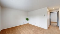 Located on Cherrywood Avenue in Bellingham, Washington, this one-bedroom, one-bathroom unit offers a practical and well-organized single-floor layout. The living room is carpeted and bright, featuring a large window with blinds that frames views of the surrounding neighborhood greenery, along with baseboard heating and a textured ceiling throughout.

A notable feature of this unit is its dual kitchen configuration. The primary kitchen is a galley-style space equipped with dark espresso cabinetry, a white electric range, refrigerator, dishwasher, double sink, and tile flooring — providing ample storage and functional counter space. A secondary kitchen area offers additional cabinetry, a sink, dishwasher, and a dining nook — an uncommon and versatile arrangement.

The bedroom is carpeted with a window allowing natural light, a closet with a dark wood panel door, and baseboard heating. The bathroom features tile flooring, a vanity with dark wood cabinetry, a mirrored medicine cabinet, and clean white fixtures. A hallway connects the rooms efficiently, keeping the layout cohesive. Dark wood doors are consistent throughout the unit, adding a warm contrast to the white walls and neutral carpet tones.