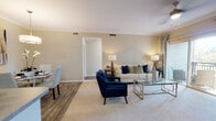 This single-floor residence at 9874 E Arizona Dr in Aurora, Colorado, offers a well-designed layout with a cohesive, neutral aesthetic carried throughout each room. The living area serves as the heart of the home, featuring plush carpeting, crown molding, a ceiling fan, and a fireplace framed by a clean mantel. Sliding glass doors open directly onto a private balcony, allowing natural light to fill the space and providing outdoor views of the surrounding landscape.

Adjacent to the living area, the dining space features wood-look flooring, crown molding, and a pendant light fixture overhead, creating a defined yet open setting. The kitchen is outfitted with dark cabinetry, stone-look countertops, stainless steel appliances including a gas range and built-in microwave, and light wood-look flooring. An in-unit laundry area is accessible directly from the kitchen.

The primary bedroom offers carpeted flooring, a ceiling fan, and an en-suite bathroom with a soaking tub and white tile surround. A second bedroom is equally well-appointed, featuring large windows that invite abundant natural light and outdoor views. The second bathroom includes wood-look flooring and a tub-shower combination.