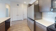 Located at 17744 Wayforest Dr in Houston, TX, this single-floor home offers a clean, modern design throughout. The open-concept layout connects the main living areas seamlessly, with warm wood-look laminate flooring extending through the living spaces and kitchen, creating a cohesive and inviting atmosphere. The living room is generously sized, featuring recessed lighting, a ceiling fan, and direct access to a private balcony through a glass door flanked by large windows that bring in abundant natural light and views of the surrounding neighborhood. The kitchen is well-appointed with dark, richly finished cabinetry, white countertops, a classic subway tile backsplash, and stainless steel appliances including a full-size refrigerator and microwave. Ample storage is provided by double closets nearby. The bedrooms are comfortably carpeted and include closets with sliding or paneled doors; one bedroom receives natural light through a window with a neighborhood view. The bathroom is finished with large-format light tile flooring, a dark-toned vanity with white countertop, a framed mirror, and a subway tile-surround tub and shower combination. Throughout the home, neutral tones and consistent finishes create a bright, move-in-ready environment.