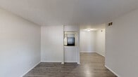 Located at 2010 S Clack St in Abilene, Texas, this single-level one-bedroom, one-bathroom residence offers a clean and functional layout with a neutral color palette throughout. The living area welcomes you with durable wood-look flooring, crisp white walls, and a front-facing window with blinds that allows natural light to fill the space. A pass-through opening connects the living room to the kitchen, enhancing the sense of openness. The galley-style kitchen is efficiently designed with gray cabinetry, light countertops, and black appliances including an electric range and a full-size refrigerator, complemented by wood-look flooring that extends from the main living areas. Hallways guide you to the private bedroom, which features plush carpeting, a ceiling fan with light fixture, and a window with blinds for natural light. The bedroom includes access to a generously sized walk-in closet fitted with dual hanging rods and shelving on both sides, providing ample storage. The bathroom offers a full tub-shower combination with white tile surround, a toilet, and a vanity with a stone-look countertop. Wood-look flooring ties the bathroom together with the rest of the home's common areas, creating a cohesive and practical living environment.