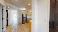 Located at 1564 Hi Point St in Los Angeles, this single-floor unit showcases a clean, contemporary design throughout. Light wood flooring flows seamlessly across every room, contributing to a warm and cohesive aesthetic. The open kitchen is well-appointed with flat-front light wood cabinetry, white quartz countertops, stainless steel appliances including a gas range, refrigerator, and dishwasher, and a striking blue patterned tile backsplash above the range that serves as a distinctive focal point. Recessed lighting illuminates the space, and a window above the sink brings in natural light.

The bedrooms are bright and generously proportioned, with crisp white walls and large windows that frame outdoor views of surrounding greenery. One bedroom features a sleek black-framed mirrored sliding closet door. The living area opens directly to a private balcony, extending the sense of space outdoors.

Two bathrooms are finished with the same light wood-toned cabinetry, white countertops, and black hardware accents. One bathroom includes a tub-shower combination with black-framed glass sliding doors, while the other offers a vanity with a framed mirror. The overall design is modern, light-filled, and thoughtfully detailed.
