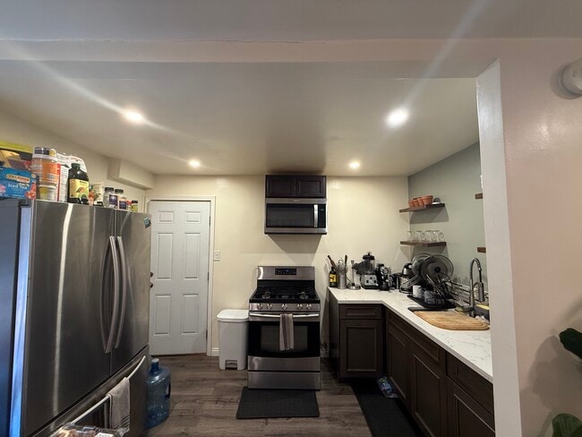 La cocina incluye electrodomésticos de acero inoxidable con encimeras de granito. - 18173 Brightman Ave