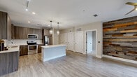 Located on Memorial Drive SE in Atlanta's vibrant Grant Park neighborhood, this well-appointed 2-bedroom, 2-bathroom residence offers a thoughtfully designed single-level layout. The contemporary kitchen is a standout, featuring sleek wood-toned cabinetry, white quartz countertops, a classic subway tile backsplash, stainless steel appliances, and elegant pendant lighting over a center island — all set atop light wood-style flooring. The open living area makes a striking impression with a reclaimed wood accent wall, ceiling fan, and wide French doors with transom windows that invite abundant natural light. Both bedrooms are carpeted and generously sized, each equipped with a ceiling fan. The primary bedroom connects directly to an en-suite bathroom featuring a glass-enclosed tiled shower and tile flooring, while the secondary bathroom offers a full tub-shower combo with coordinating tile surround and a wood-vanity with stone countertop. Each bedroom is served by its own walk-in closet outfitted with wire shelving systems for ample storage. Clean lines, neutral tones, and modern finishes throughout create a cohesive and inviting atmosphere across the entire residence.
