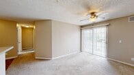 Located at 619 Orlando Ave in Normal, IL, this 2-bedroom, 2-bathroom unit offers a practical and well-organized single-floor layout. The open-concept living and kitchen area forms the heart of the unit, where warm beige tones and neutral finishes create a cohesive, understated aesthetic. The living room features plush carpeting, a ceiling fan with light fixture, and sliding glass doors that provide access to a balcony and allow natural light to fill the space. Adjacent to the living area, the kitchen is equipped with hardwood-style flooring, white cabinetry, light granite-style countertops, a double sink, a dishwasher, and black appliances including a refrigerator and range. A textured ceiling is consistent throughout the unit. Both bedrooms are carpeted and finished with neutral walls and white trim, offering a clean and quiet retreat. The primary bedroom is notably spacious, with a window providing natural light. The secondary bedroom also features a window with outdoor views. The two bathrooms include one with a full tub/shower combo and one with hardwood-style flooring and a vanity with a light stone-top. The overall ambiance is functional, clean, and move-in ready.