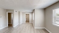 Located at 2728 N Buckner Blvd in Dallas, Texas, this single-story unit offers a clean, updated interior with a neutral color palette throughout. The open living area is finished with light wood-look luxury vinyl plank flooring and features multiple windows that invite natural light, creating a bright and welcoming atmosphere. The textured ceilings are consistent throughout the common areas and bedrooms, adding a classic residential character.

The kitchen is appointed with white cabinetry, brushed nickel hardware, and a marble-patterned laminate countertop, providing ample storage and prep space. It connects conveniently to the main living area, supporting an open flow through the unit.

The bedrooms are carpeted for comfort and feature textured ceilings, HVAC vents, and generous closet space — one bedroom includes a built-in closet with shelving. Natural light enters through windows with blinds, offering views of the surrounding neighborhood.

The bathroom is a notable highlight, featuring a soaking tub and shower combination with large-format marble-look tile surround and brushed nickel fixtures, lending a contemporary, refined aesthetic.

Overall, the unit presents a practical and well-maintained living space with consistent, modern updates suitable for everyday living in the East Dallas area.