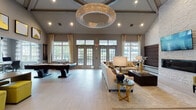 Located at 327 Mill Plain Road in Milford, Connecticut, this single-story amenity facility offers a thoughtfully designed collection of social and wellness spaces. The centerpiece is a generously proportioned lounge and game room characterized by soaring vaulted ceilings, large multi-pane French doors, and an abundance of natural light. A dramatic circular crystal chandelier anchors the space overhead, while light-toned tile flooring, neutral wall tones, and gold-accented furnishings establish a refined, contemporary aesthetic. A full-size billiards table occupies one end of the room, complemented by plush sectional seating and a textured stone accent wall with an integrated media display.

An adjacent wet bar area features sleek dark-wood cabinetry, quartz countertops, under-counter refrigeration, open floating shelves, and a striking geometric tile backsplash. A cozy library nook offers floor-to-ceiling built-in shelving, velvet accent chairs in warm gold tones, and additional decorative display space.

The fitness center is well-appointed with cardio equipment including treadmills and ellipticals, a cable strength-training machine, free weights, and exercise balls. Full-length mirrors visually expand the space, while a dedicated bay-windowed stretching and functional training room with rubberized flooring and outdoor views completes the wellness offering.