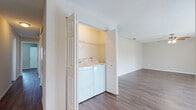 Located at 501 116th Ave N in Saint Petersburg, Florida, this single-floor residence offers a practical and comfortable layout throughout. Rich, dark hardwood-style flooring flows consistently through the living areas, bedrooms, and hallways, lending a cohesive and modern feel to the entire space. Textured ceilings are present throughout, adding a classic touch to each room.

The spacious living area is bright and open, benefiting from natural light filtered through slatted blinds. A ceiling fan with integrated lighting provides both comfort and functionality. The kitchen is well-equipped, featuring white cabinetry, granite-style countertops, and stainless steel appliances, including a range with hood ventilation, all illuminated by a window overlooking the exterior.

The hallway connects the various rooms efficiently, with flush-mount lighting guiding the way. Bedrooms are generously sized, each offering ample natural light through large windows with blinds. The bathroom includes a wide vanity with granite-style countertops, white cabinetry, a large mirror with overhead lighting, and a full tub-shower combination with clean white tile surround.

A notable feature is the in-unit laundry closet, housing a full-size washer and dryer behind bi-fold doors with built-in shelving above—adding significant everyday convenience to this well-maintained Saint Petersburg residence.