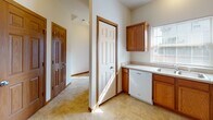 Located at 2704 Westmar Ct in Toledo, Ohio, this two-story home offers a practical and comfortable layout spread across two levels connected by a wood-railed staircase. The main level features a combined dining and living area, where plush carpeting and a pendant chandelier create a welcoming atmosphere. A sliding glass door in the living area fills the space with natural light and provides direct access to the outdoors. The kitchen is well-appointed with warm oak cabinetry, ample counter space, a double-basin sink, a dishwasher, and tile flooring, with a window above the sink offering additional natural light. The upper level hosts multiple carpeted bedrooms, each equipped with ceiling fans and windows dressed with blinds. The bedrooms are generously sized, with six-panel wood doors and wood trim detailing throughout. Bathrooms are finished with oak vanities topped with solid countertops, large mirrors, and tile flooring. One bathroom includes a tub and shower combination. Consistent wood trim, neutral wall tones, and carpeted living spaces tie the home together with a cohesive, classic aesthetic throughout both floors.