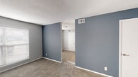 This single-floor unit at 4216 Garrett Rd in Durham, NC offers a straightforward, functional layout with several notable updates throughout. The living and bedroom areas feature wall-to-wall carpet in neutral tones, complemented by light gray walls that create a calm, cohesive atmosphere. Textured ceilings are consistent throughout the carpeted rooms, and each space is equipped with standard HVAC vents for year-round climate control. A window with horizontal blinds in one of the carpeted rooms allows natural light to filter in, brightening the interior.

The kitchen stands out as a well-appointed space, featuring white cabinetry, granite-look countertops, and a classic subway tile backsplash. Stainless steel appliances — including a refrigerator, dishwasher, microwave, and electric range — are included, and light wood-look flooring ties the space together cleanly. Flush overhead lighting provides ample illumination.

The bathroom continues the updated aesthetic with wood-look vinyl flooring, white cabinetry, and a clean, minimal design. A tub/shower combination, toilet, and vanity are neatly arranged within the space. The 3D floor plan illustrates a compact but efficient overall layout, with clearly defined rooms connected by a central corridor.