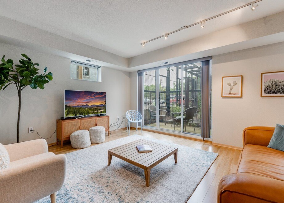 Living room with a TV, couch, coffee table, and access to a patio.