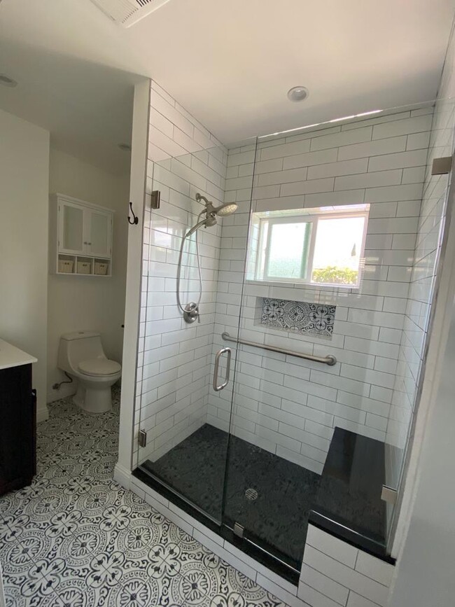 Sizeable bathroom with tiled shower and built in bench. - 9345 Woodley Ave
