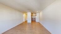 Located at 11054 Warwick Blvd in Newport News, VA, this two-bedroom, one-bathroom single-floor unit offers a clean, functional layout with a cohesive design throughout. Light wood-style flooring runs continuously across the entire space, lending warmth and visual continuity from room to room.

The entry hallway leads into an open living area bathed in natural light from a front-facing door with sidelights. The living space flows directly into the kitchen, which is partially separated by a structural dividing wall. The kitchen features warm oak cabinetry with ample upper and lower storage, dark laminate countertops, a double-basin sink, and white Whirlpool appliances including a refrigerator, electric range, and over-the-range microwave.

The spacious primary bedroom offers a generous footprint with two closets and ceiling ventilation, providing practical storage and airflow. The second bedroom is comfortably sized with a window that allows for natural light and neighborhood views. Both bedrooms share a full bathroom fitted with a wood-toned vanity, a single-sink countertop, and a full-size tub/shower combo. The neutral wall palette and light flooring throughout create a bright, clean atmosphere well-suited for everyday living.
