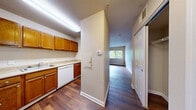 Located at 200 S Ironton St in Aurora, CO, this two-bedroom, one-bathroom unit offers a practical and well-organized single-floor layout. The kitchen is efficiently designed with warm oak cabinetry extending to the upper walls, light-toned countertops, a stainless steel sink, a white electric range, and a dishwasher — providing ample storage and workspace for everyday cooking. Wood-style flooring runs throughout the main living and kitchen areas, lending a cohesive, easy-to-maintain aesthetic. A hallway connects the main living areas to the bedrooms and bathroom, with a dedicated closet offering additional storage. The primary bedroom is a comfortable size, featuring wood-style flooring and a window that frames views of surrounding trees, filling the room with natural light. The second bedroom is carpeted and similarly bright, with its own window overlooking greenery. The bathroom is well-appointed with a single-sink vanity topped with a light countertop, a large mirror with overhead lighting, a walk-in glass-door shower stall, and wood-style flooring. An adjacent closet with built-in shelving provides convenient storage. The overall ambiance is clean, neutral, and functional — well-suited for those seeking a straightforward, low-maintenance living space in Aurora.
