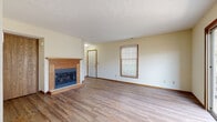 Located at 1234 Buckingham Gate Blvd in Cuyahoga Falls, Ohio, this two-floor home offers a practical and comfortable layout designed for everyday living. The main level features an open living area with hardwood-style flooring, neutral walls, and a wood-trimmed fireplace that serves as a focal point of the room. Natural light filters in through windows fitted with horizontal blinds, and a door provides access to the exterior. An adjacent open space with a sliding glass patio door leads to an outdoor deck area, while a dining nook is distinguished by a bold blue accent wall and a pendant light overhead.

The kitchen is outfitted with oak cabinetry, white appliances including a refrigerator and dishwasher, a built-in sink, and hardwood-style flooring. A full bathroom on this level includes a walk-in shower stall and hardwood-style flooring. Upstairs, carpeted bedrooms offer a quieter, softer environment, each with a window for natural light. A second full bathroom features a vanity with oak cabinetry, a shower-tub combination, and hardwood-style flooring. A carpeted staircase with a wood handrail connects the two levels, completing this well-structured home.