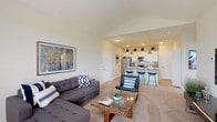 Located at 7027 Park Mill Dr in Plain City, Ohio, this single-floor residence offers a thoughtfully designed open-concept layout that seamlessly connects the main living areas. The living room is a standout space, featuring soaring vaulted ceilings that amplify the sense of openness, soft carpeted flooring, and a large window that invites an abundance of natural light while offering views of the surrounding landscape. A dining area sits adjacent, providing a relaxed space for everyday meals.

The kitchen is well-appointed with white shaker-style cabinetry, granite countertops, and a full suite of stainless steel appliances including a refrigerator, range, and over-the-range microwave. A kitchen island with bar seating serves as both a functional prep space and a casual gathering spot, illuminated by polished pendant lights overhead. Light wood-tone flooring ties the kitchen and adjacent areas together with a clean, modern aesthetic.

The bathroom features light wood-style flooring, a granite-topped vanity, and a window that brings in natural light while maintaining privacy. Throughout the residence, neutral tones, recessed lighting, and clean lines create a cohesive and contemporary ambiance that is both functional and inviting.