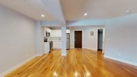 Unit 412 at 5959 Broadway in the Riverdale neighborhood of the Bronx offers a thoughtfully renovated, single-floor residence defined by an open-concept layout and warm hardwood flooring throughout the main living area. The generous open floor plan allows for flexible furniture arrangements, with recessed lighting overhead and light-toned walls creating a bright, welcoming atmosphere. Structural columns subtly define zones within the space without interrupting its overall sense of openness.

The kitchen is seamlessly integrated into the living area and features white shaker-style cabinetry, white subway tile backsplash, light quartz countertops, and a full suite of stainless steel appliances, including an electric range, over-the-range microwave, and refrigerator. A stainless steel undermount sink with a modern faucet completes the clean, contemporary aesthetic.

The bathroom continues the renovated design with white subway tile lining the tub surround, a sliding glass shower door, and a white vanity with an undermount sink, offering a crisp, updated feel. A closet is accessible off the main living area, providing practical storage. Natural light enters through windows visible from the living space, enhancing the overall airy quality of the unit.