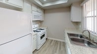 Located at 4620 Van Buren Blvd in Riverside, California, this single-floor residence offers a clean, neutral aesthetic throughout. The living area is a welcoming, open space featuring soft wall-to-wall carpeting and a sliding glass door that opens to a private balcony, filling the room with natural light and providing views of the surrounding neighborhood. A ceiling-mounted HVAC vent and textured popcorn ceiling add practical detail to the space.

The kitchen is efficiently designed with light wood-style flooring, white cabinetry, granite-patterned countertops, and a full suite of white appliances including a gas range, over-the-range microwave, and refrigerator. A recessed ceiling detail above the cooking area adds subtle architectural interest, while the stainless steel sink completes the functional layout.

The bedroom is a generously sized, carpeted retreat with a window that allows natural light to filter in, creating a calm and comfortable atmosphere. A ceiling fan adds airflow and comfort to the adjacent area visible from the bedroom corridor.

The bathroom features a wide granite-topped vanity with white cabinetry, a large framed mirror, and a Hollywood-style light bar. A separate water closet area includes a bathtub with shower and toilet. Wood-style flooring ties the space together with a cohesive, modern feel throughout.