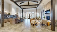 Located at 1329 SW Pumice Ave in Redmond, Oregon, this single-story community clubhouse offers a generously sized, open-plan gathering space defined by striking architectural character. The centerpiece of the main area is a dramatic vaulted ceiling adorned with bold, dark-stained wood beams that cross overhead, lending a rustic yet refined aesthetic throughout. Large-format stone tile flooring flows seamlessly across the open layout, grounding the space with an earthy, durable elegance.

The fully equipped kitchen is a standout feature, boasting a substantial island with bar seating, wood-toned cabinetry, open shelving, a decorative patterned tile backsplash, and stainless steel appliances — all topped by pendant lighting that adds a warm, modern touch. Adjacent to the kitchen, the lounge area offers ample seating arranged around a floor-to-ceiling tiled fireplace with a mounted television, ideal for communal gatherings.

The entry foyer welcomes visitors with a statement chandelier and a reclaimed wood accent wall, while a private office or consultation nook features its own reclaimed wood feature wall and carpeted flooring. A dedicated game room, painted in deep navy blue, houses a ping pong table and shuffleboard, with large windows providing natural light. Together, these spaces create an inviting, well-appointed community hub.