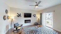 This single-floor Cumberland residence features a well-appointed open layout that seamlessly connects the main living areas. The living room is a welcoming central space with wood-style flooring, a ceiling fan, a wall-mounted electric fireplace, and a sliding glass door that opens to a private balcony, allowing natural light to pour in. Adjacent to the living room, a dedicated dining area provides a comfortable setting for shared meals.

The kitchen is designed for functionality and style, featuring dark cabinetry, granite-style countertops, stainless steel appliances, and pendant lighting above a spacious breakfast bar with seating. The layout makes the kitchen an efficient hub that flows naturally into the dining and living spaces.

The three bedrooms are carpeted for comfort, with large windows that invite natural light. Ceiling fans are present in select bedrooms, adding to the airy feel. The two full bathrooms are finished with large-format tile flooring, dark vanity cabinetry, white countertops, and shower-tub combinations or walk-in showers. Throughout the home, neutral tones and consistent finishes create a cohesive and modern aesthetic.