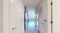 Located at 1258 El Camino Real in Menlo Park, California, this single-floor unit offers a clean, modern design throughout. The interior is finished with light wood-tone flooring that runs seamlessly across all areas, complemented by crisp white walls that create a bright and airy atmosphere.

The kitchen is thoughtfully designed with warm wood-grain cabinetry extending from floor to ceiling, offering ample storage. Stainless steel appliances — including a gas range, microwave, and refrigerator — are paired with white quartz countertops and a subway tile backsplash, giving the space a contemporary yet functional feel. Recessed lighting adds to the clean aesthetic.

A central hallway connects the various spaces efficiently, featuring a sliding barn-style door and louvered closet doors that add subtle architectural character. The main living area receives generous natural light through a bank of large windows overlooking the surrounding neighborhood. Additional rooms provide flexible, versatile spaces, each finished with the same consistent light flooring and white walls.

The bathroom is well-appointed with a tiled soaking tub and shower combination featuring marble-style surround panels, mosaic tile flooring, a wood-vanity with white countertop, and a backlit mirror, bringing a spa-like quality to the space. Overall, the unit presents a cohesive, modern aesthetic with quality finishes throughout.