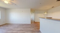 Located at 1703 Mission Bay Cir in Rockledge, FL, this two-bedroom, two-bathroom residence offers a well-organized single-floor layout with a clean, neutral aesthetic throughout. The open-concept living and dining area is finished with light wood-look laminate flooring, white walls, and a textured ceiling, creating a bright and airy atmosphere. A peninsula with granite-style countertop separates the living space from the galley-style kitchen, which is equipped with light wood cabinetry, matching granite-style countertops, and white appliances including a range, refrigerator, and dishwasher. The two bedrooms are carpeted for comfort and filled with natural light from windows. The primary bedroom features a spacious walk-in closet with wire shelving that spans two walls, offering generous storage. The second bedroom includes a full-width bi-fold closet. Both bathrooms are finished with wood-look flooring, light wood vanity cabinetry with granite-style countertops, and tiled tub-shower combinations. The consistent use of light tones and practical finishes throughout the space creates a cohesive and move-in ready environment.