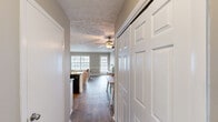 Located at 501 Leisure Lake Dr in Warner Robins, GA, this well-appointed single-floor, one-bedroom, one-bathroom residence offers an efficient and comfortable layout. The combined kitchen and living area forms the heart of the home, filled with natural light from multiple windows and featuring durable wood-style flooring, crown molding, and a decorative textured ceiling with a ceiling fan. The living room provides a welcoming atmosphere with neutral warm-toned walls, a chair rail accent, and a glass-paned exterior door that brightens the space further. The kitchen is thoughtfully designed with white cabinetry, dark granite-style countertops, black appliances including an electric range and refrigerator, a stainless steel sink, and a convenient breakfast bar peninsula. Crown molding adds a refined touch overhead. The bedroom is a comfortable retreat carpeted for warmth, with a ceiling fan, a natural light window with blinds, and an open closet offering ample storage. The bathroom includes white cabinetry, dark countertops, a well-lit vanity mirror, and a shower-tub combination. Neutral tones and consistent finishes throughout create a cohesive and inviting ambiance, making this a practical and charming home.