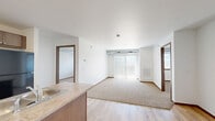 Located at 2109 E Anamosa St in Rapid City, South Dakota, this single-floor, 2-bedroom, 3-bathroom residence offers a practical and well-organized layout. The open-concept living and kitchen area serves as the heart of the home, with light wood-style flooring flowing through the kitchen and transitioning to plush carpet in the living space. The kitchen is equipped with dark cabinetry, a peninsula with a built-in sink, and black appliances including a refrigerator, range, and microwave. A sliding glass door in the living area invites natural light and provides access to outdoor views.

Both bedrooms feature neutral carpet, white walls with warm wood trim, and windows that frame expansive views of the surrounding Rapid City landscape. The primary bedroom offers a comfortable, well-proportioned retreat. Three bathrooms provide ample convenience, each featuring hexagonal marble-style tile flooring and clean white tub-shower combinations with dark wood vanities. A dedicated laundry room includes a full-size washer and dryer, adding everyday practicality. The overall aesthetic is clean, neutral, and functional — well-suited for comfortable everyday living.