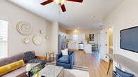 Located at 8250 Cliffdale Rd in Fayetteville, NC, this two-story home offers a well-designed layout with functional living spaces throughout. The main floor presents an open-concept design where the living room, dining area, and kitchen flow seamlessly together. Light wood-style flooring runs throughout the main level, complementing the neutral wall tones and contributing to a bright, airy atmosphere. Ceiling fans are installed in key living areas, enhancing comfort year-round. The kitchen is outfitted with white cabinetry, stainless steel appliances including a refrigerator, range, microwave, and dishwasher, along with a breakfast bar that provides additional seating. A dedicated dining nook with access to an adjacent room adds versatility to the main floor. A staircase leads to the upper level, where the bedrooms are situated. The carpeted bedrooms offer a comfortable retreat, with the primary bedroom featuring an en-suite bathroom and a walk-in closet with built-in wire shelving. Additional bedrooms are well-sized with natural light from windows. The bathrooms include white vanities with light countertops and a tub-shower combination. A separate laundry area with wire shelving overhead and washer/dryer hookups completes the upper floor.