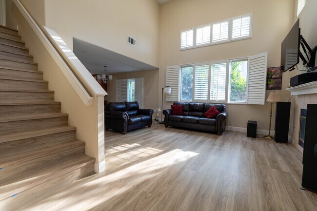 Sala de estar con techos abovedados, chimenea a gas y accesorios LED empotrados inteligentes con regulación regulable. - 8781 Arbor St